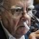 Older man looking concerned sniffing wine